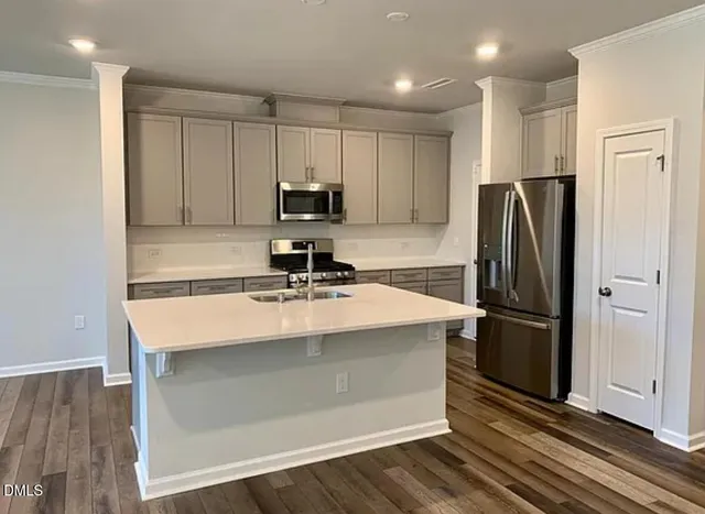a kitchen with kitchen island a sink appliances and cabinets