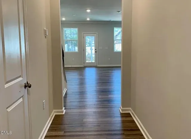 a view of a hallway with wooden floor and staircase