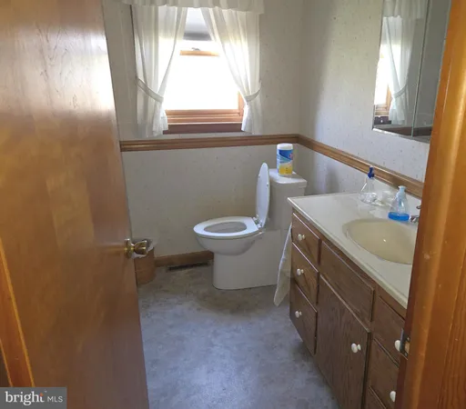 a bathroom with a sink toilet and a window