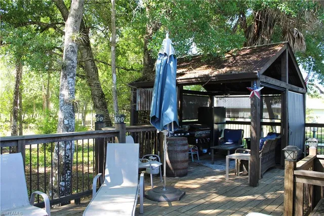 a view of a patio with table and chairs potted plants and large tree