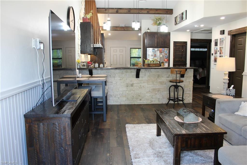 6285 Parkers Hammock Road, Unit B Naples, FL 34112 - Photo 7 of 33 a living room with furniture and a chandelier