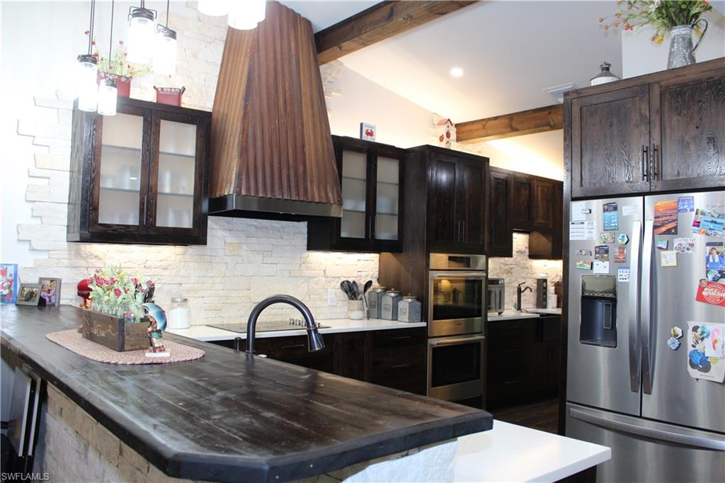 6285 Parkers Hammock Road, Unit B Naples, FL 34112 - Photo 9 of 33 a kitchen with granite countertop a refrigerator and a stove top oven
