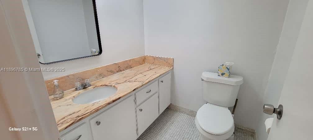 5401 Collins Avenue, Unit 214 Miami Beach, FL 33140 - Photo 17 of 37 a bathroom with a granite countertop toilet sink and mirror