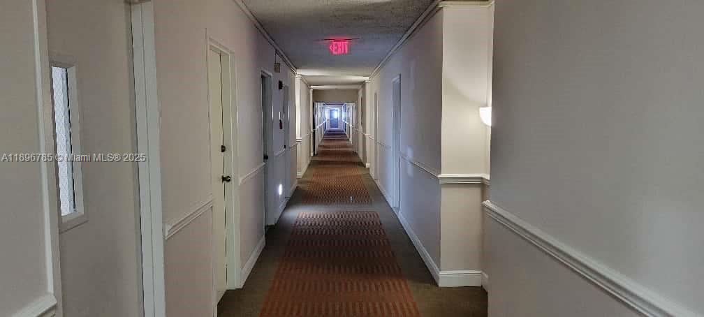 5401 Collins Avenue, Unit 214 Miami Beach, FL 33140 - Photo 5 of 37 a view of a hallway with wooden floor and stairs