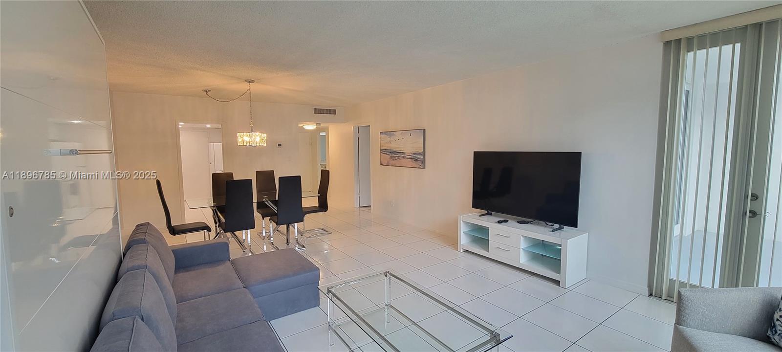 5401 Collins Avenue, Unit 214 Miami Beach, FL 33140 - Photo 7 of 37 a living room with furniture and a flat screen tv