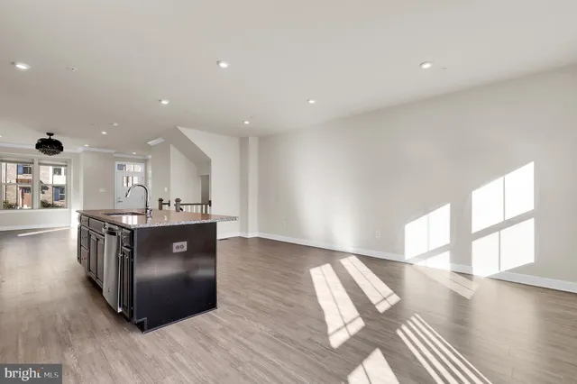 a living room with hard wood floors and a kitchen
