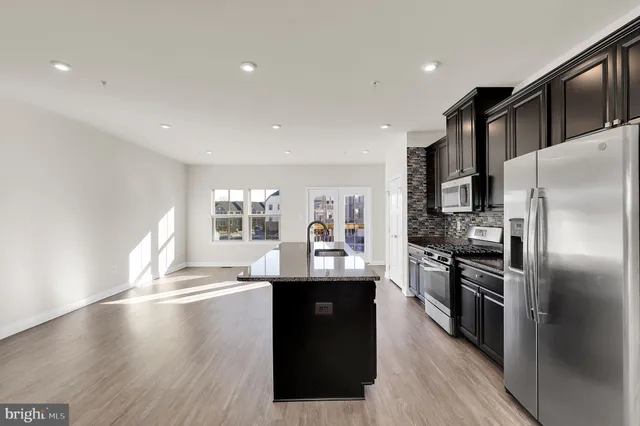 a kitchen with granite countertop a refrigerator and a stove top oven