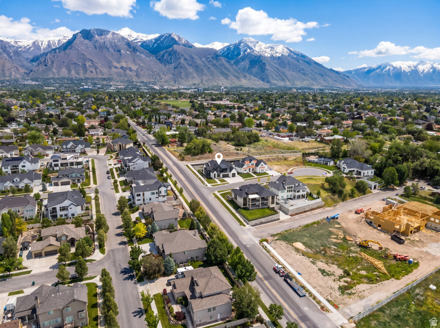 1682 North 1950 W Street, Unit 9 Provo, UT 84604 - Photo 72 of 84 Expansive mountain range backdrop surrounding a residential area with diverse architectural styles, mature trees, and a developed road network