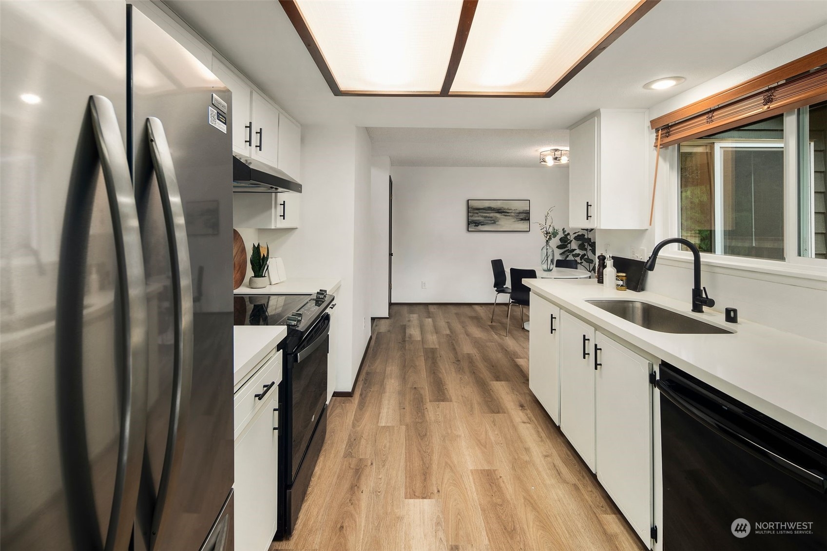 6104 145th Street Southwest Edmonds, WA 98026 - Photo 11 of 29 a kitchen with sink a refrigerator and wooden floor