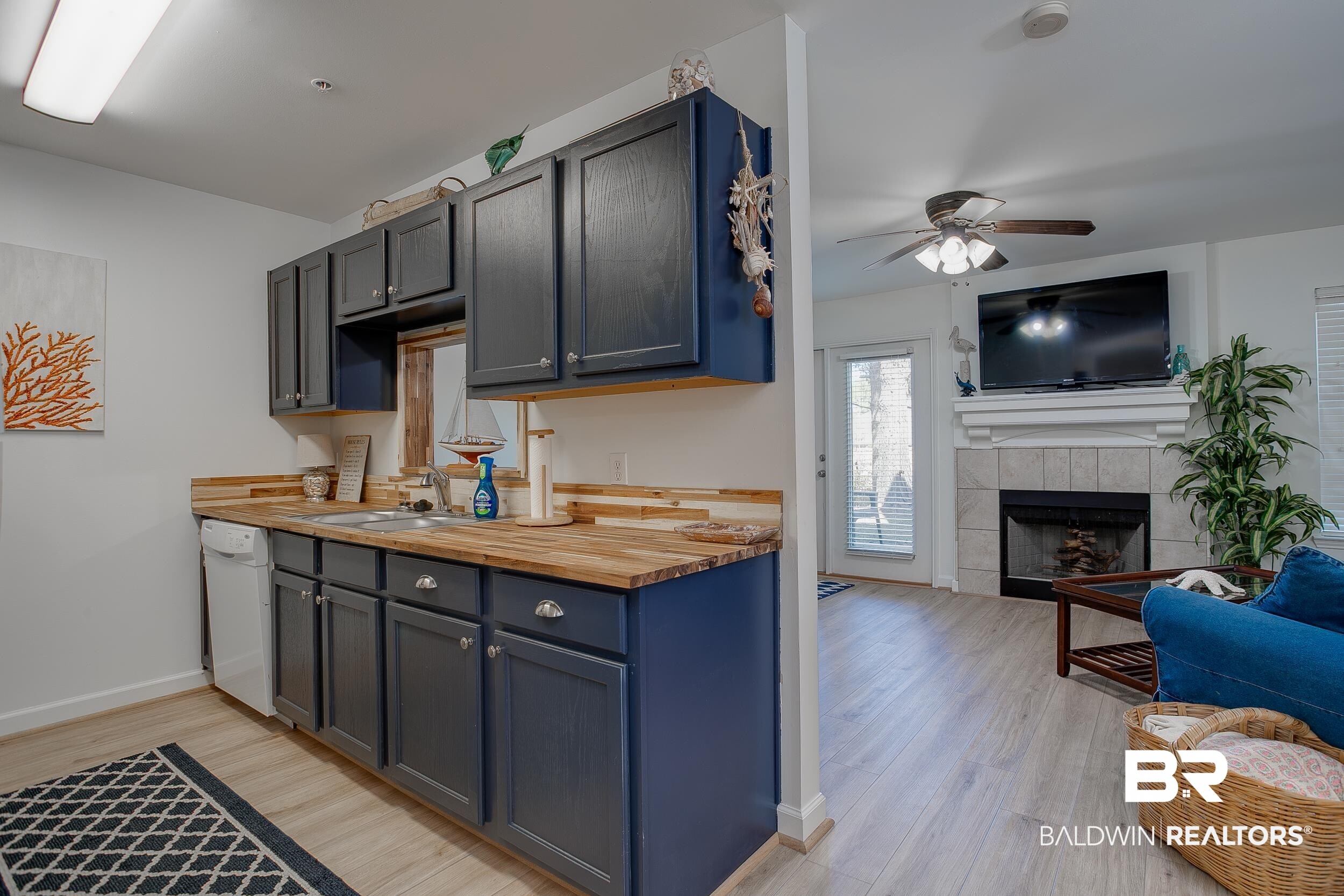 1517 Regency Road, Unit 33 Gulf Shores, AL 36542 - Photo 2 of 29 Kitchen featuring light wood-type flooring, a sink, a fireplace, white dishwasher, and wooden counters