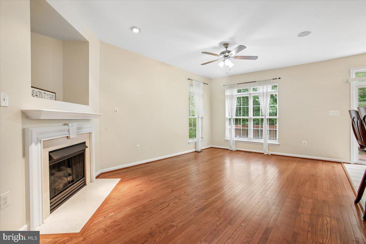 7301 Oldham Leeds Way Springfield, VA 22150 - Photo 11 of 34 an empty room with wooden floor fireplace cabinet and windows