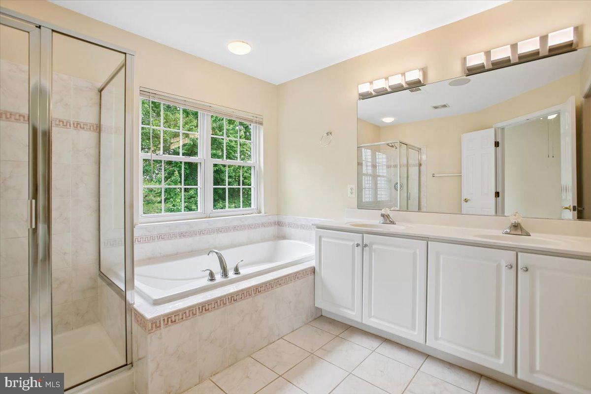 7301 Oldham Leeds Way Springfield, VA 22150 - Photo 17 of 34 a large white bathroom with a large tub sink and vanity