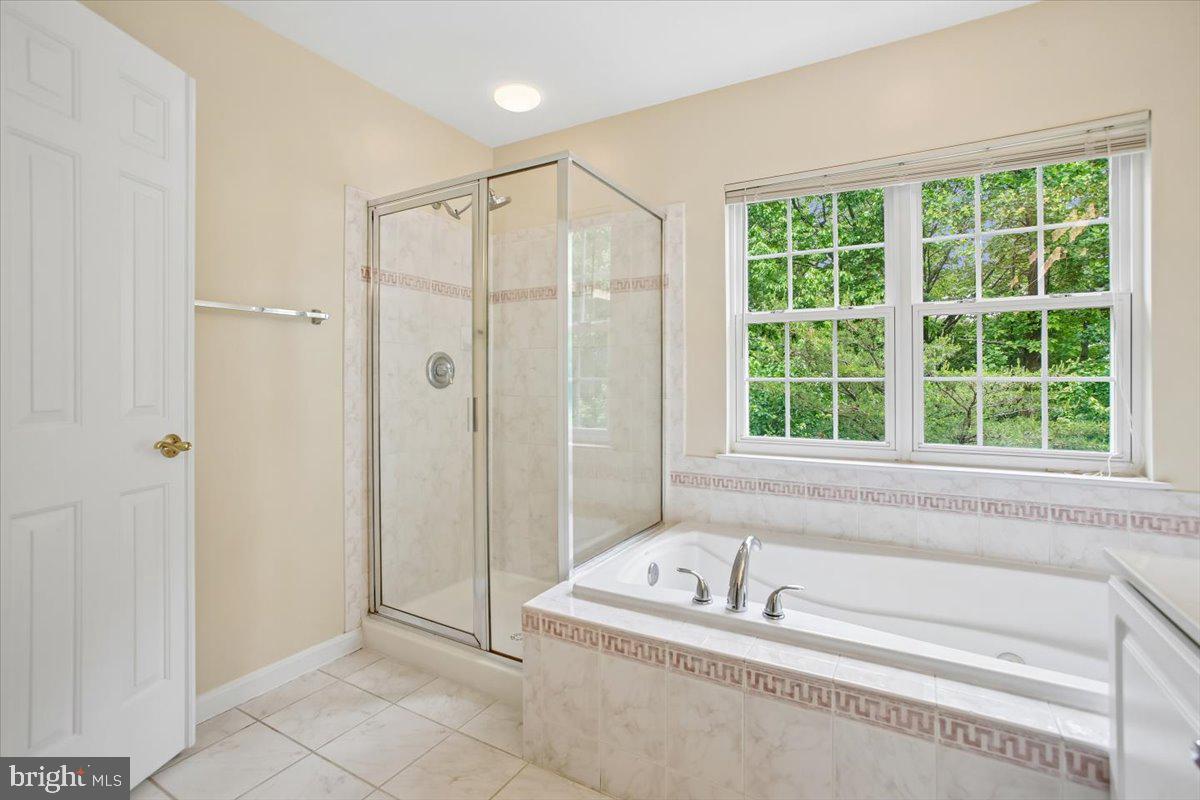 7301 Oldham Leeds Way Springfield, VA 22150 - Photo 18 of 34 a bathroom with a tub a window and a shower