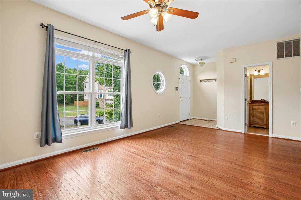 7301 Oldham Leeds Way Springfield, VA 22150 - Photo 7 of 34 a view of an empty room with a window and wooden floor