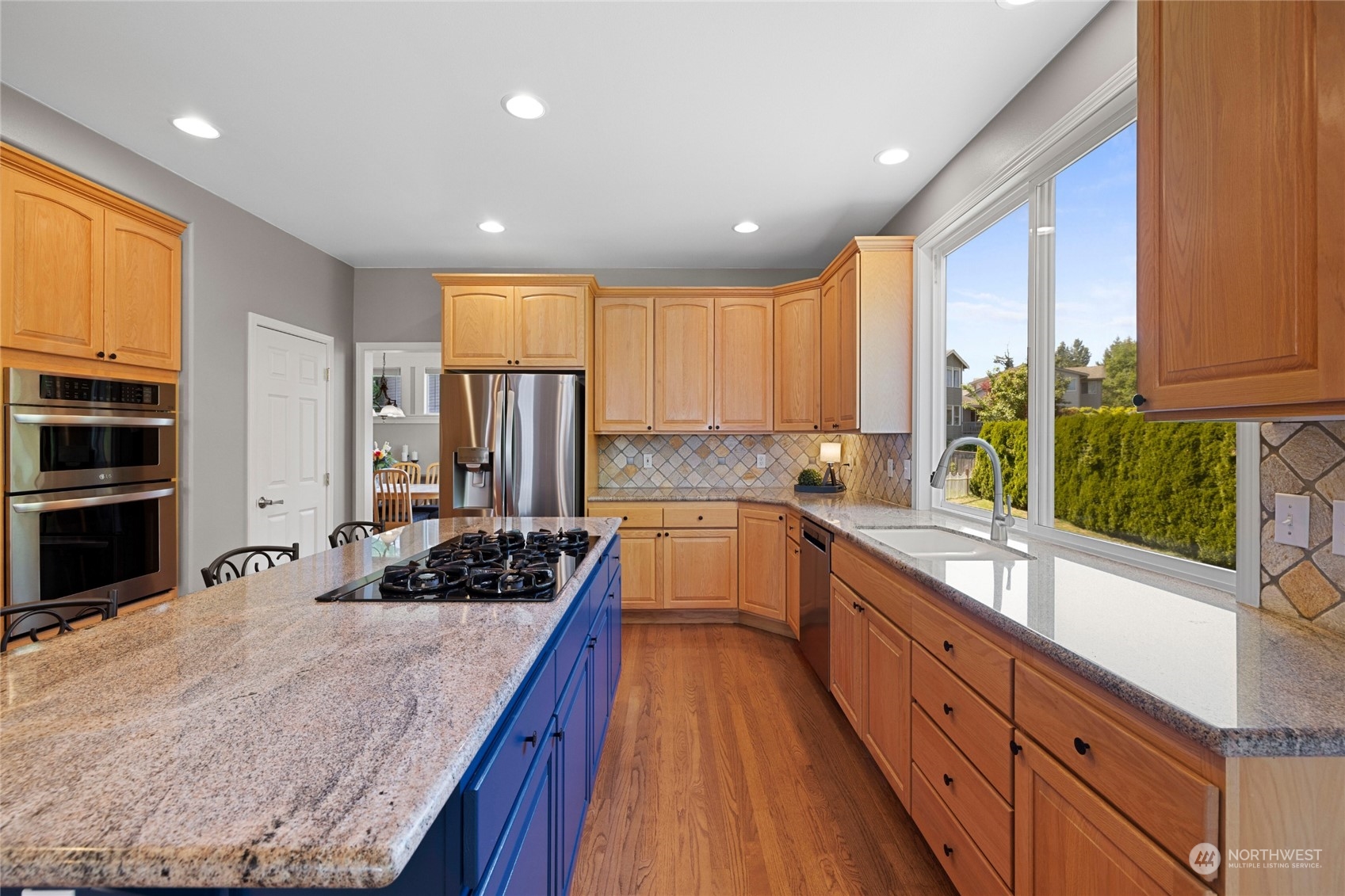 1427 236th Street Southeast Bothell, WA 98021 - Photo 8 of 40 a kitchen with kitchen island granite countertop a sink a counter top space stainless steel appliances and cabinets