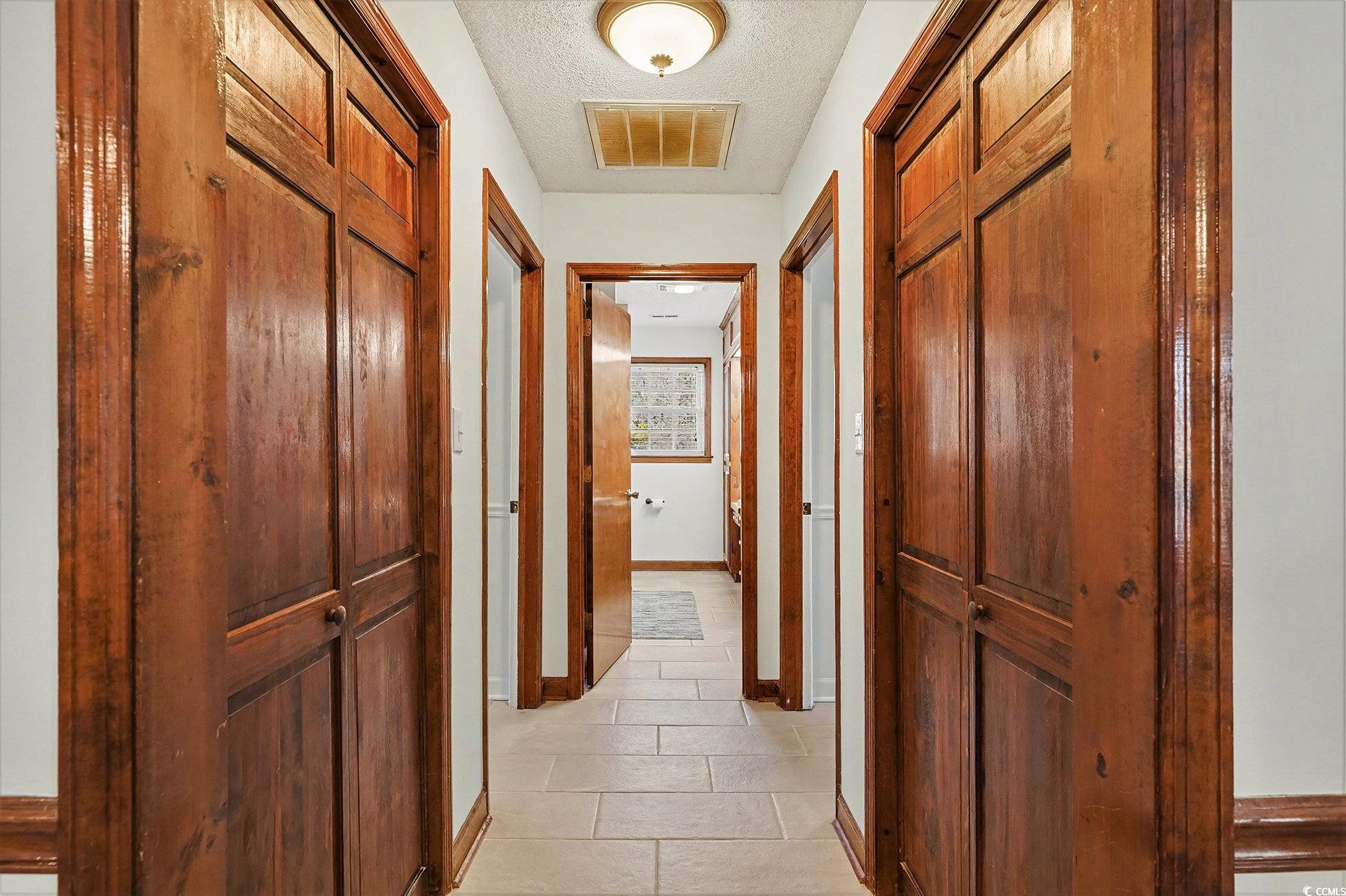 5175 Bottle Branch Road Conway, SC 29527 - Photo 12 of 28 Kitchen featuring brown cabinetry, white appliances, light tile patterned floors, a textured ceiling, and backsplash