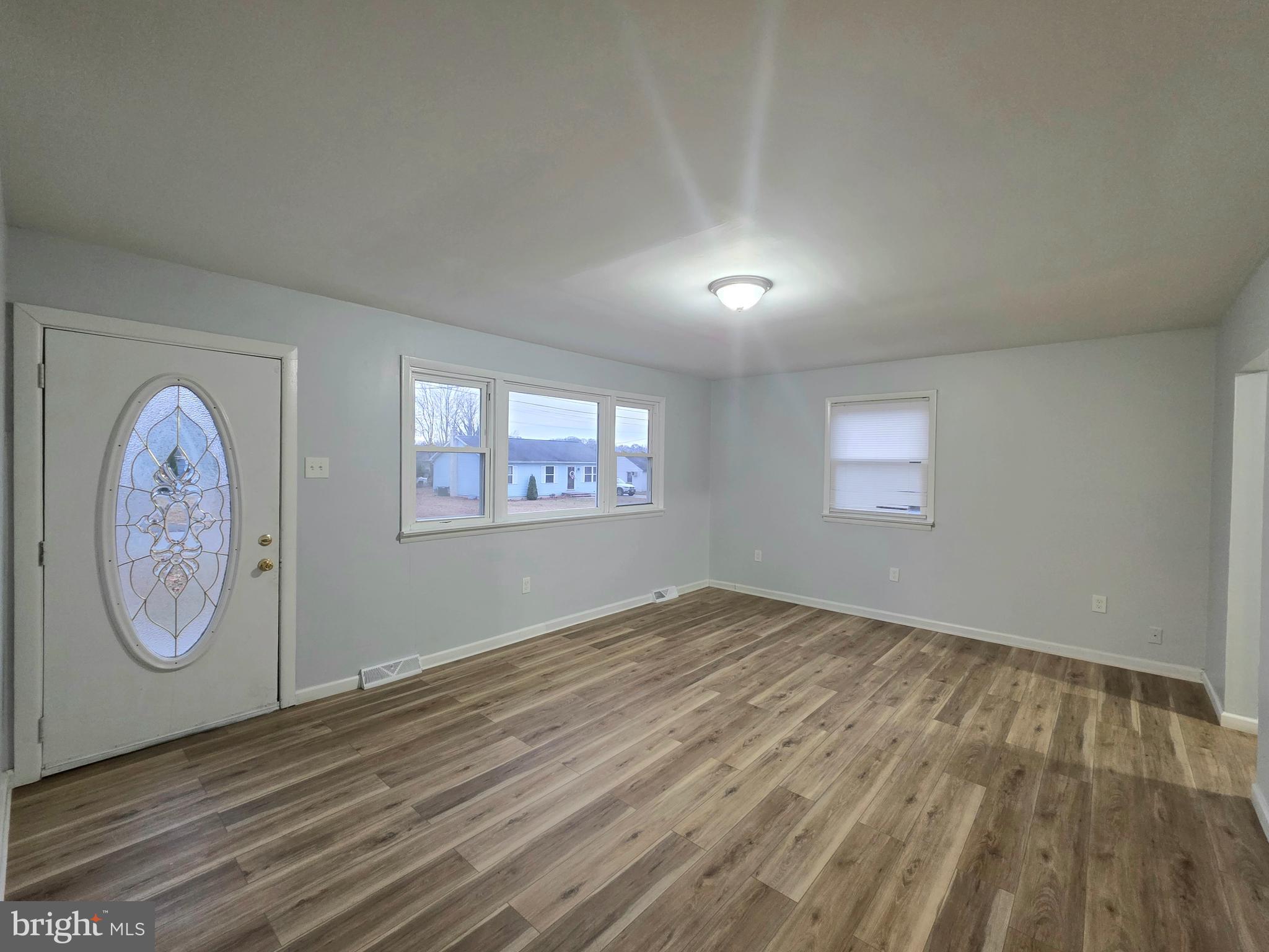11 Fairview Avenue Bridgeton, NJ 08302 - Photo 14 of 33 an empty room with wooden floor and windows