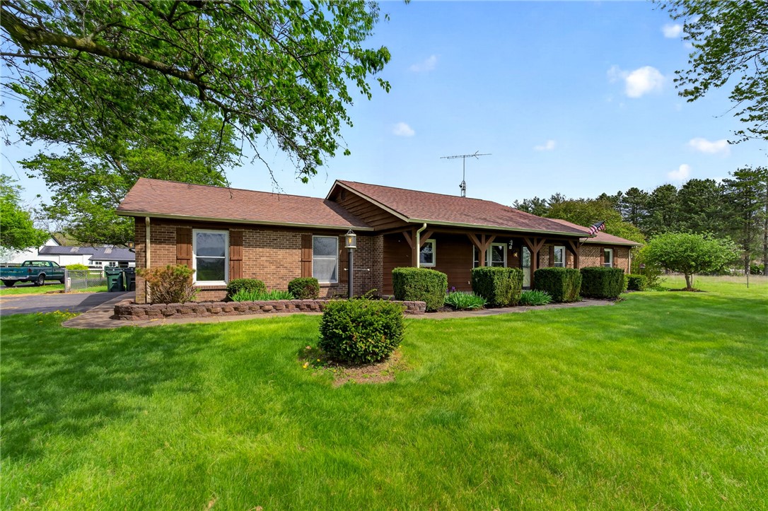 7988 McCool Road Greenville, OH 45331 - Photo 38 of 50 This ranch-style residence features a brick and wood facade with a spacious front yard.