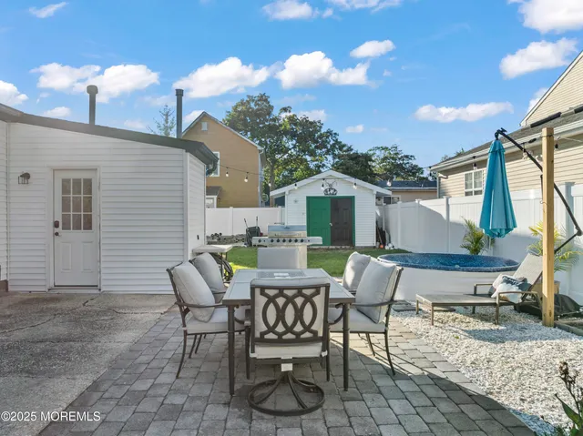a patio with table and chairs and potted plants