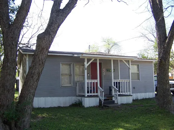 a view of backyard with barbeque grill and a large tree