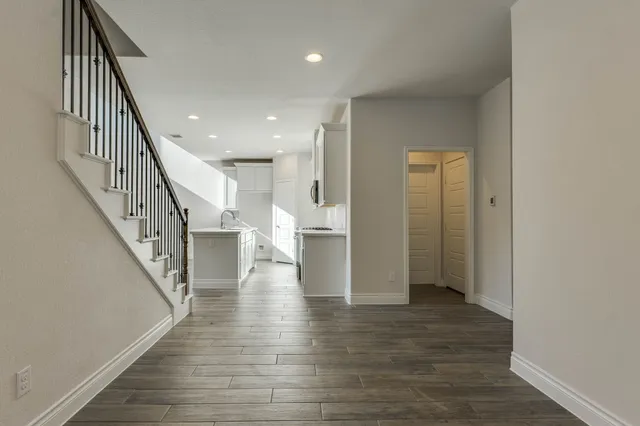 a view of a hallway with wooden floor and staircase