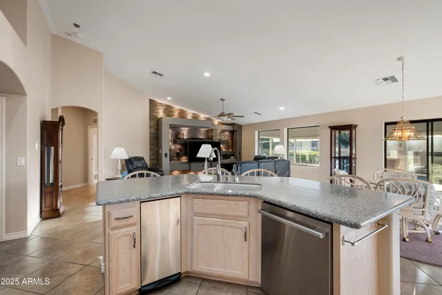 a kitchen with kitchen island granite countertop a sink and dishwasher with white cabinets