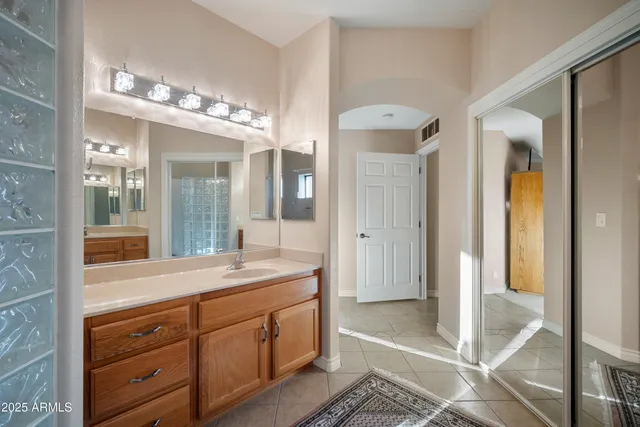a spacious bathroom with a granite countertop sink mirror and shower