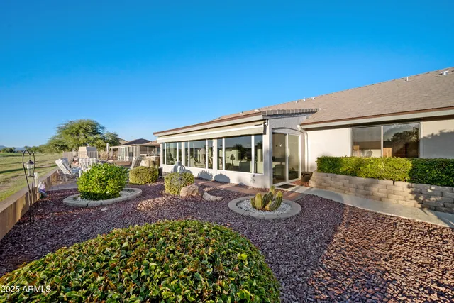 a view of a house with backyard sitting area and garden