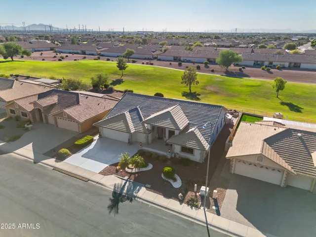 an aerial view of a house with a garden and lake view