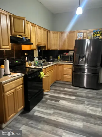 a kitchen with a refrigerator stove top oven a sink and dishwasher