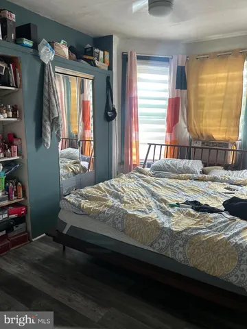 a bedroom with a bed wooden floor and a window