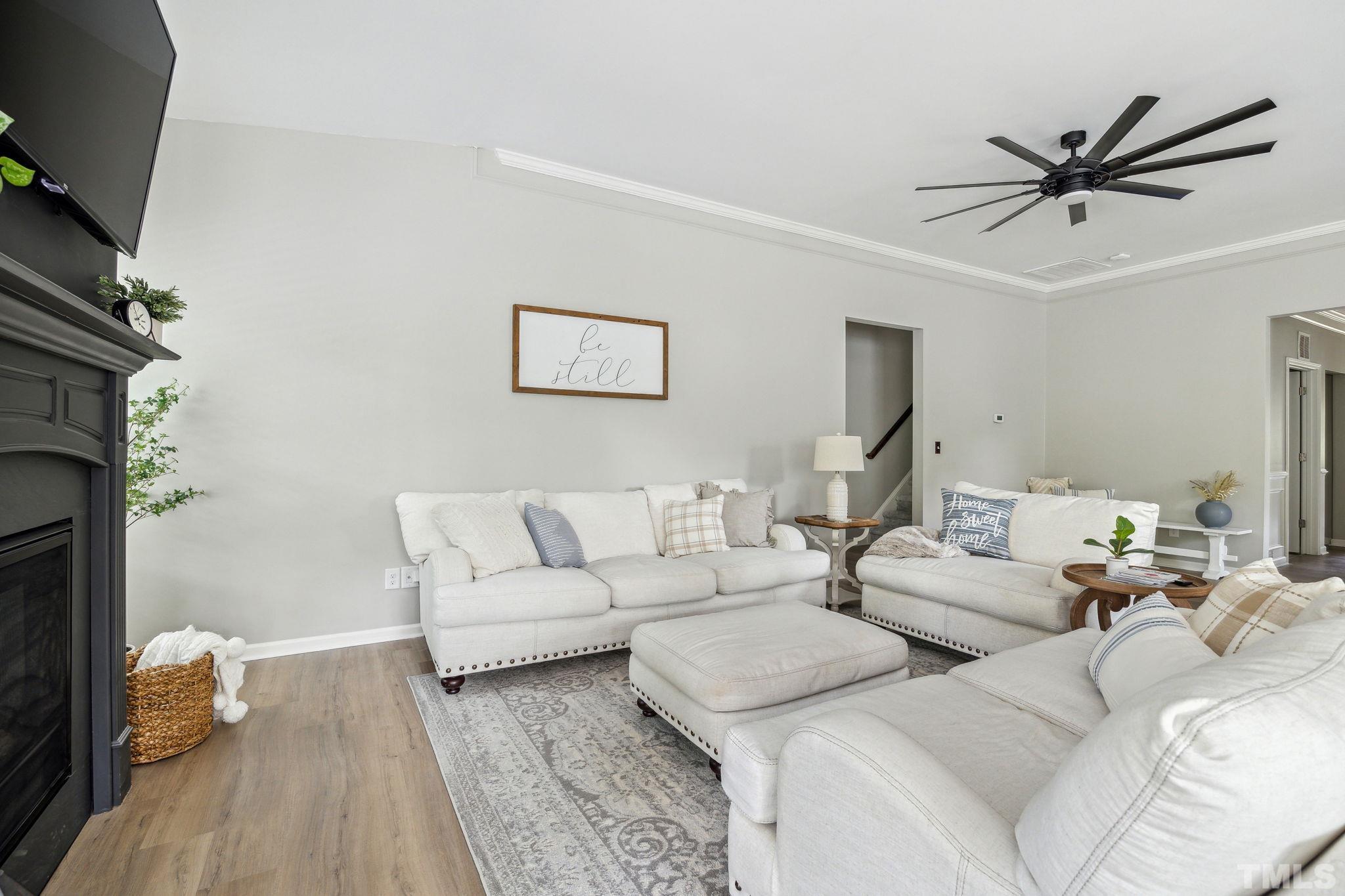505 Miners Loop Sanford, NC 27330 - Photo 13 of 45 a living room with couches a fireplace and a flat screen tv