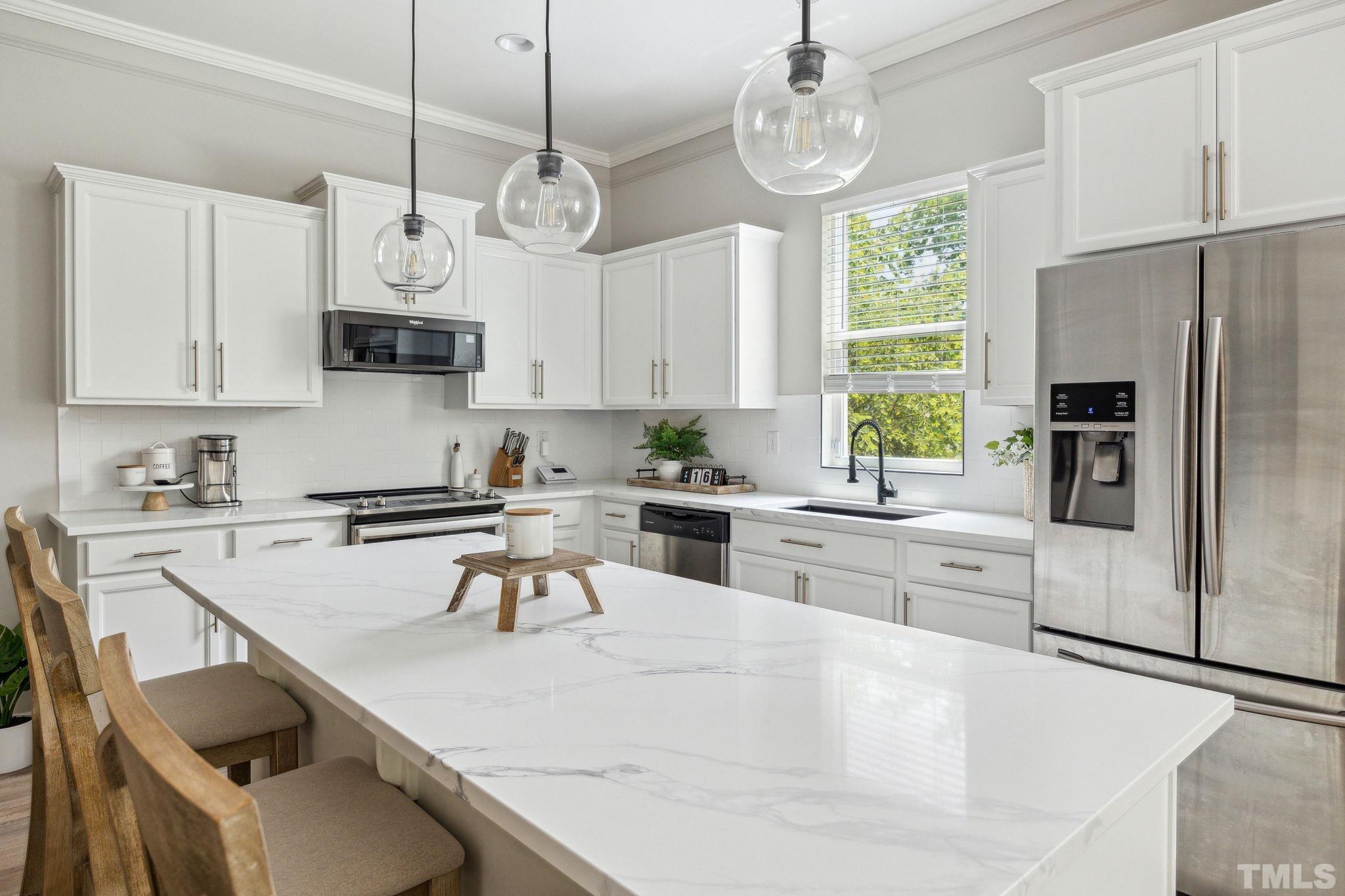 505 Miners Loop Sanford, NC 27330 - Photo 18 of 45 a kitchen with stainless steel appliances granite countertop a sink a stove a refrigerator cabinets and chairs