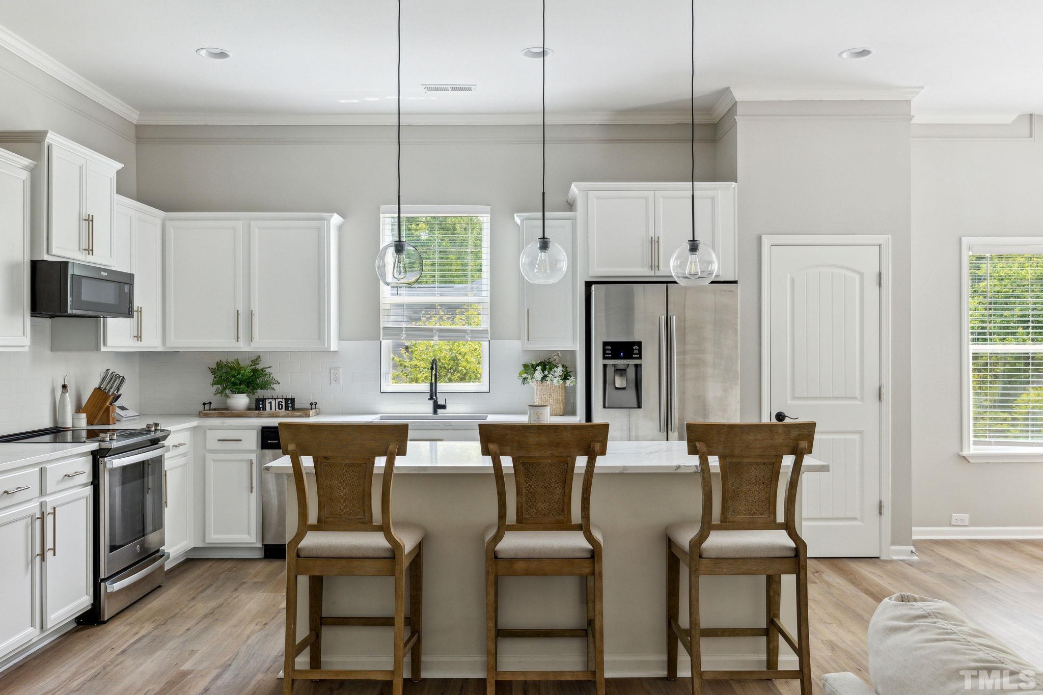 505 Miners Loop Sanford, NC 27330 - Photo 19 of 45 a kitchen with stainless steel appliances a dining table chairs and a refrigerator