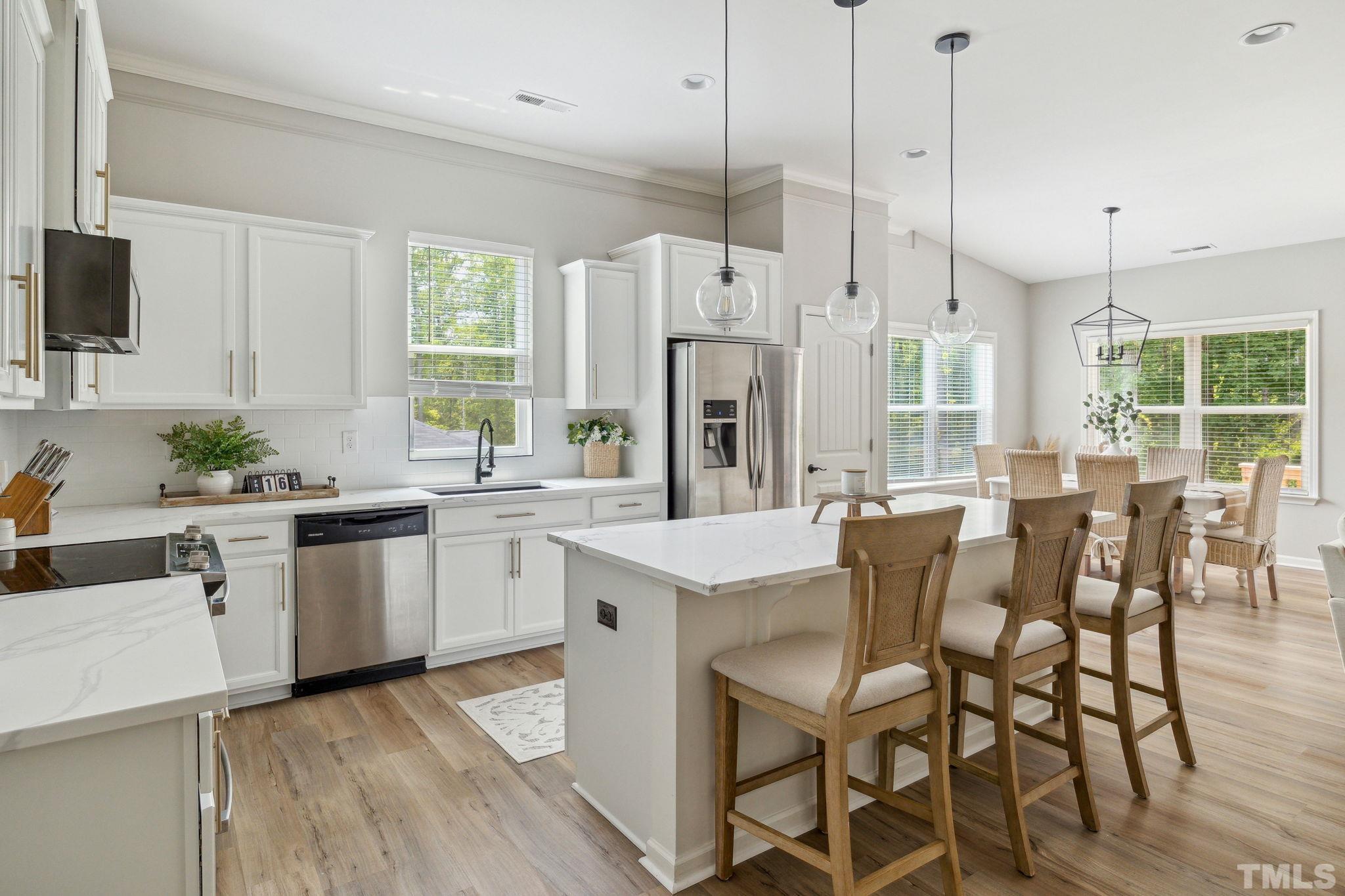 505 Miners Loop Sanford, NC 27330 - Photo 20 of 45 a kitchen with stainless steel appliances granite countertop a table chairs refrigerator and sink