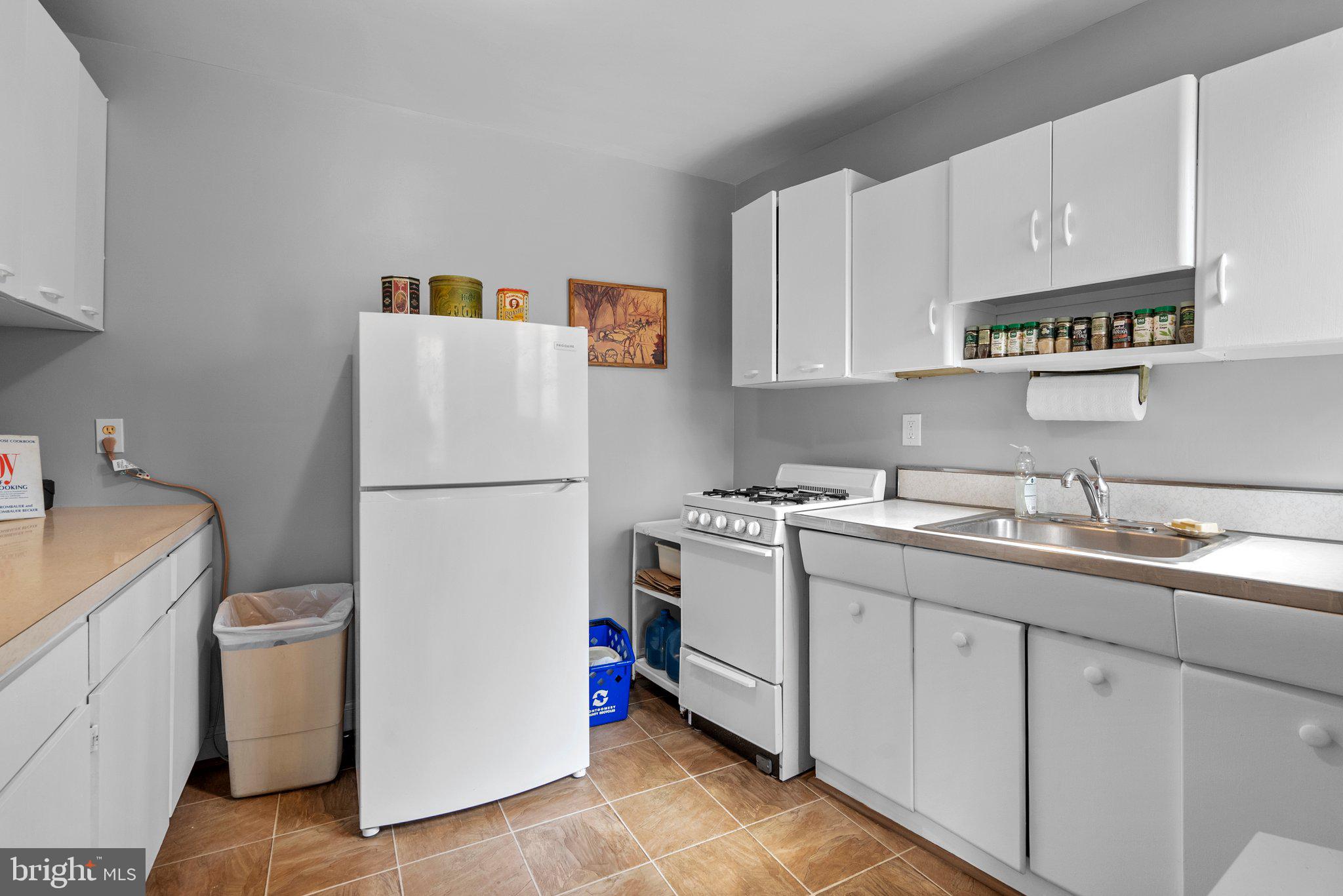 8720 Manchester Road, Unit 4 Silver Spring, MD 20901 - Photo 13 of 28 a kitchen with a sink a refrigerator and cabinets