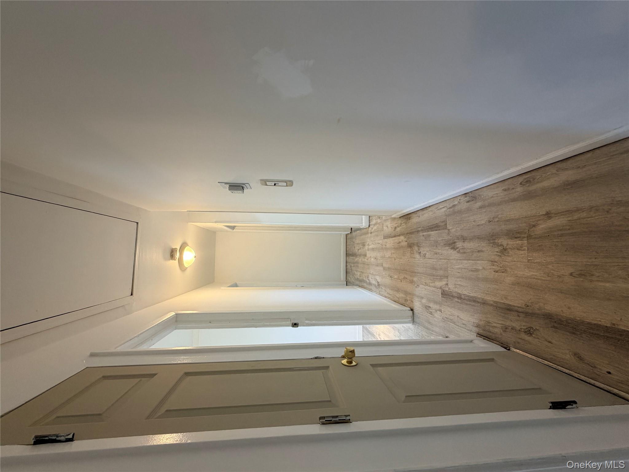 717 Doane Avenue Bellport, NY 11713 - Photo 3 of 12 a view of a hallway with wooden floor