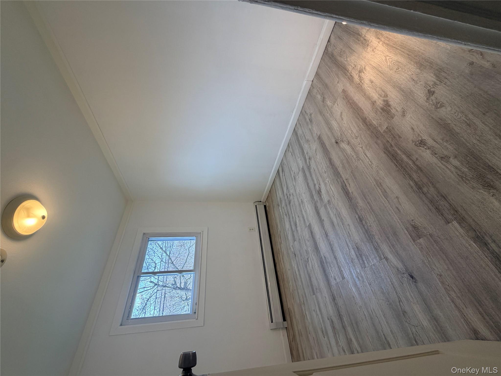 717 Doane Avenue Bellport, NY 11713 - Photo 9 of 12 an empty room with wooden floor and windows