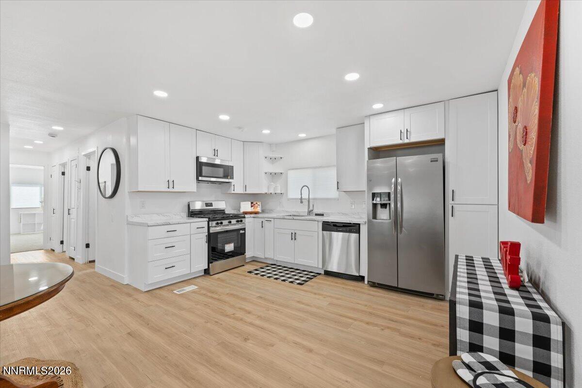 384 Loster Way Sun Valley, NV 89433 - Photo 11 of 35 a kitchen with stainless steel appliances granite countertop a refrigerator sink and cabinets