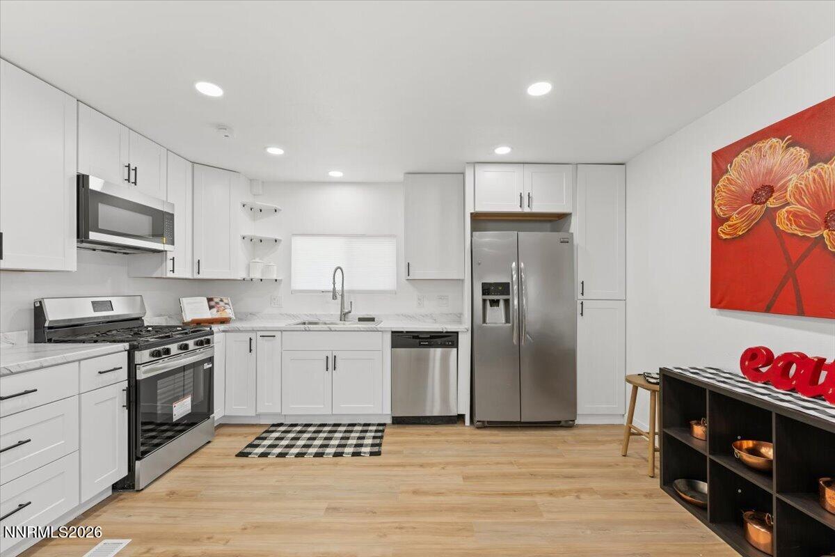 384 Loster Way Sun Valley, NV 89433 - Photo 12 of 35 a kitchen with stainless steel appliances granite countertop a refrigerator and a stove top oven