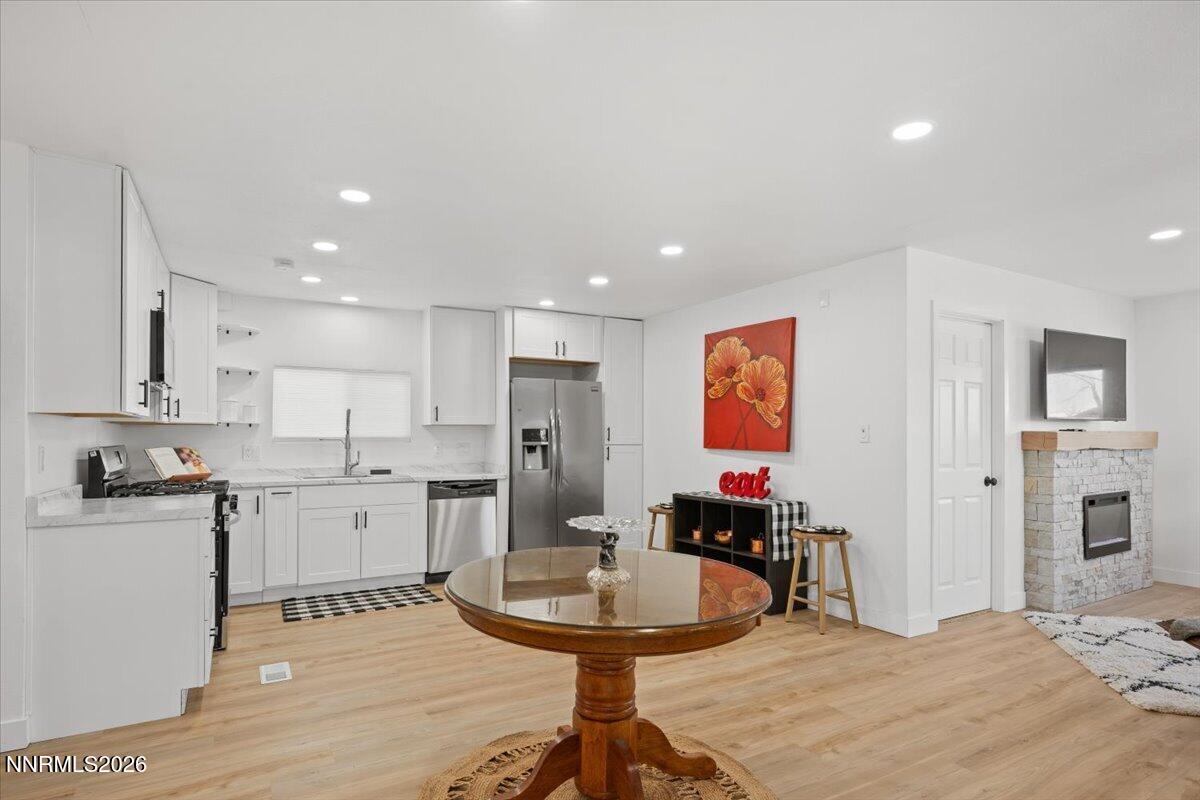 384 Loster Way Sun Valley, NV 89433 - Photo 13 of 35 a room with stainless steel appliances kitchen island granite countertop a sink and cabinets