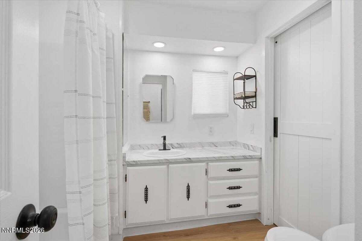 384 Loster Way Sun Valley, NV 89433 - Photo 24 of 35 a bathroom with a sink a toilet a mirror and shower