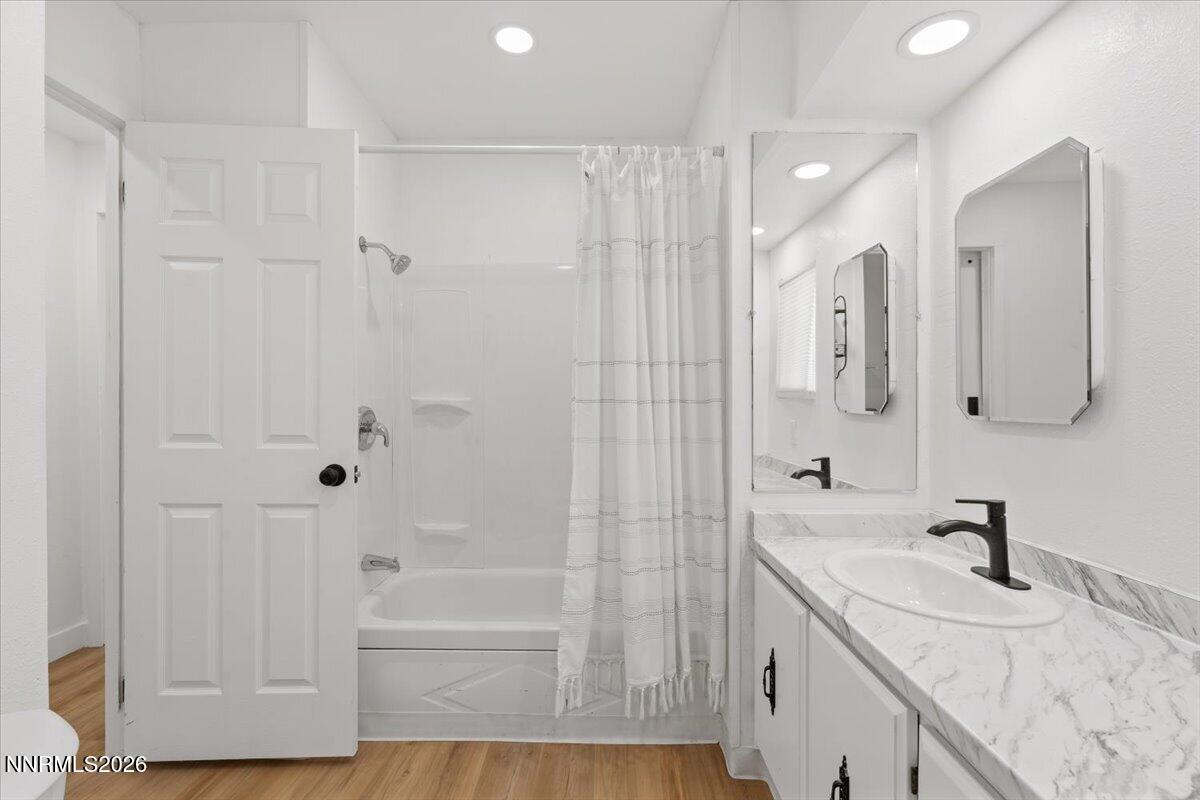384 Loster Way Sun Valley, NV 89433 - Photo 25 of 35 a bathroom with a granite countertop sink a toilet and shower