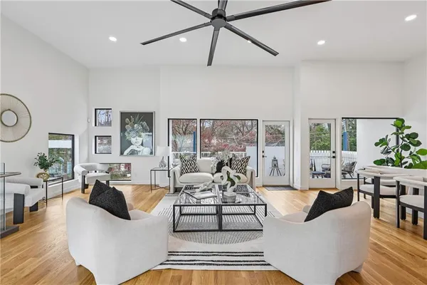 a living room with furniture wooden floor and a large window