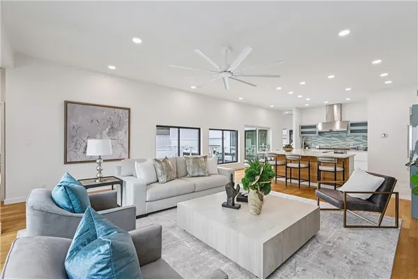 a living room with furniture white walls and kitchen view