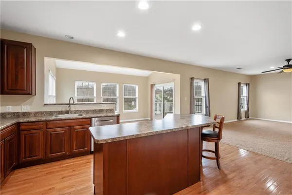 a kitchen with stainless steel appliances granite countertop a sink table and chairs