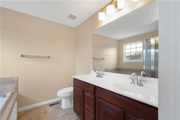 a bathroom with a double vanity sink toilet and a mirror