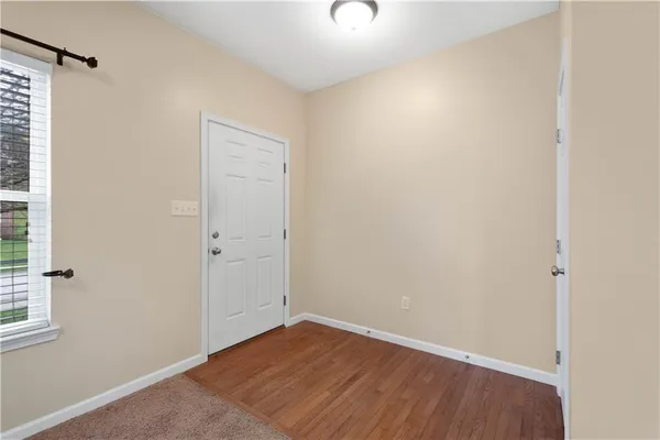 a view of an empty room with closet and a window