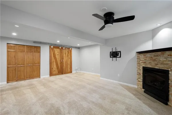 a view of empty room with a fireplace and a ceiling fan