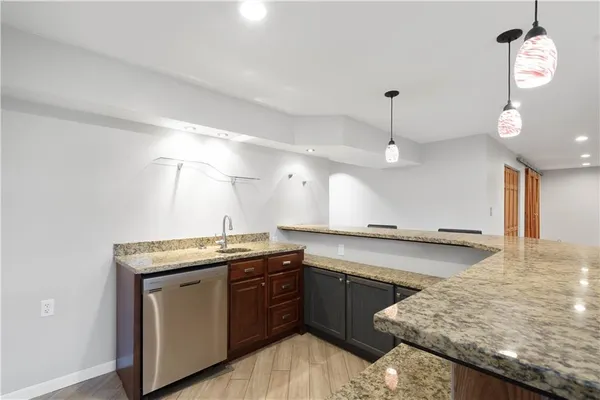 a kitchen with stainless steel appliances granite countertop a sink a stove and a wooden floors
